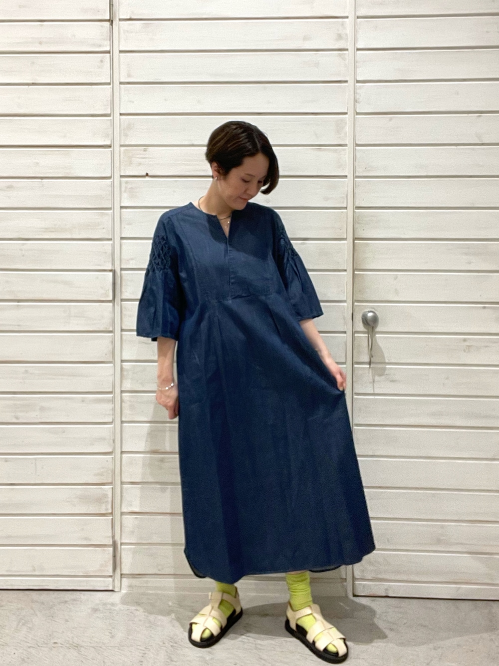 「デニム、ワンピース、刺繍、大人カジュアル、サンダル、休日コーデ、ソックス、シンプルコーデ、楽チンコーデ、フレアスリーブ」｜「FIL DE FERのスモッグ刺繍　フロント重ねワンピース（ワンピース、ブルー系）」を使った、kaji.さん（レディース・163cm）の春コーディネートの1枚目の写真