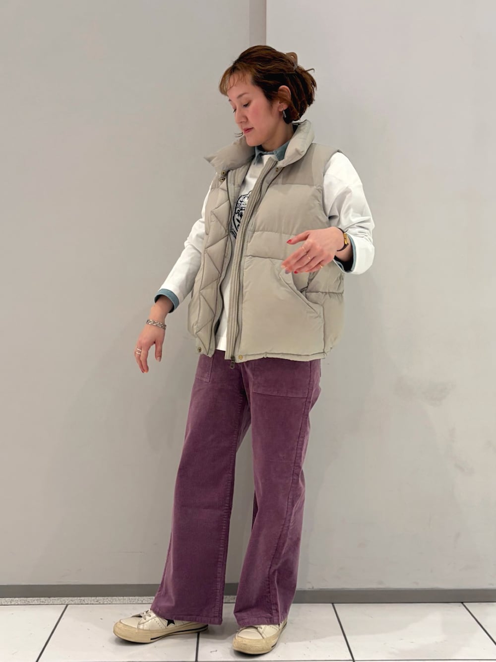 パープル系のその他パンツ、ベージュ系のダウンベスト、ブルー系のシャツ/ブラウスを着用したレディースの冬コーディネートの1枚目の写真