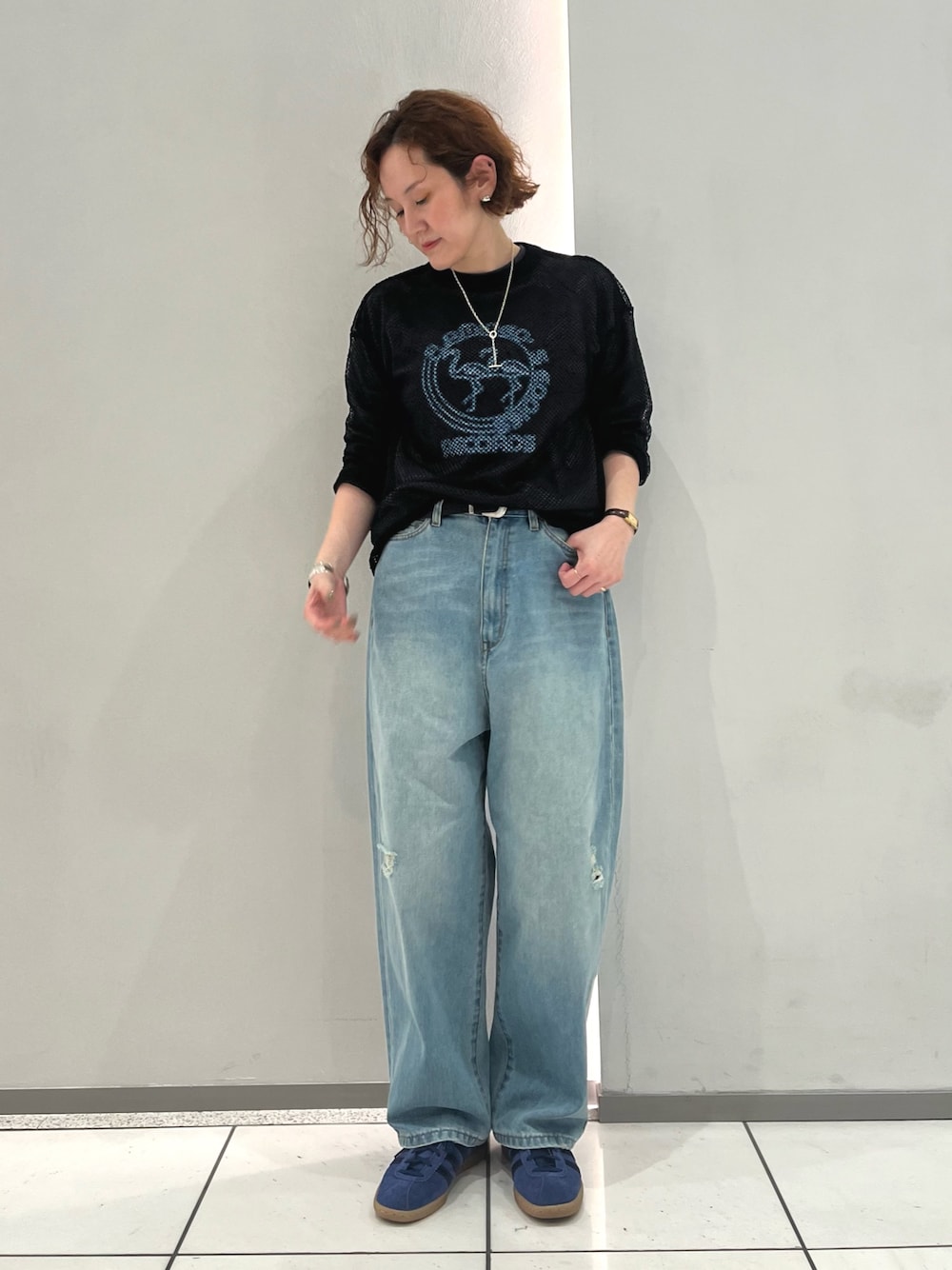 グレー系のTシャツ/カットソー、ブラック系のTシャツ/カットソー、ブルー系のデニムパンツを着用したレディースの秋コーディネートの1枚目の写真