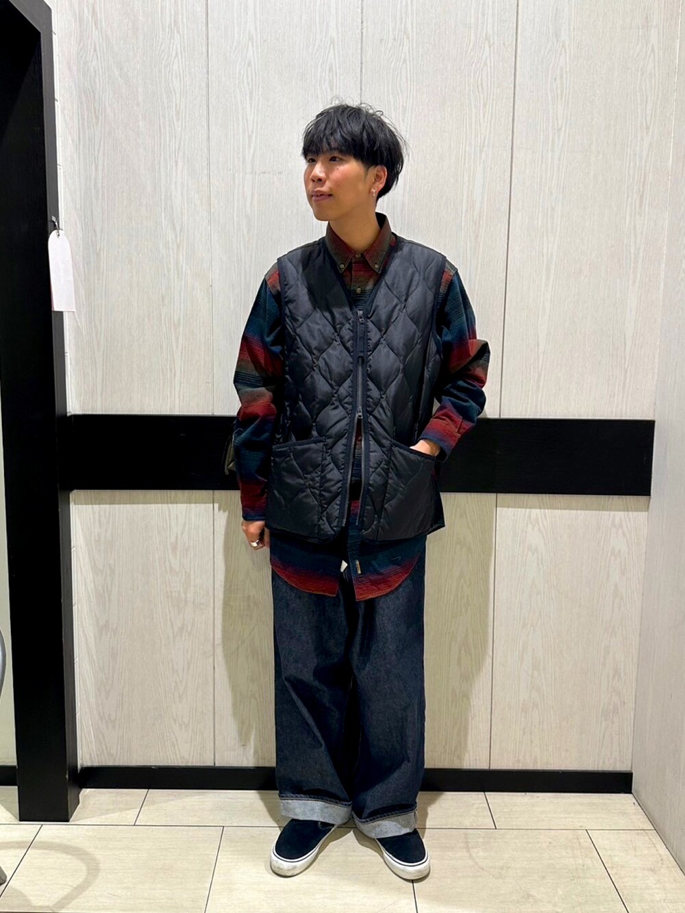 ブルー系のデニムパンツ、ブラック系のベスト、ブラック系のその他シューズを着用したメンズの冬コーディネートの1枚目の写真