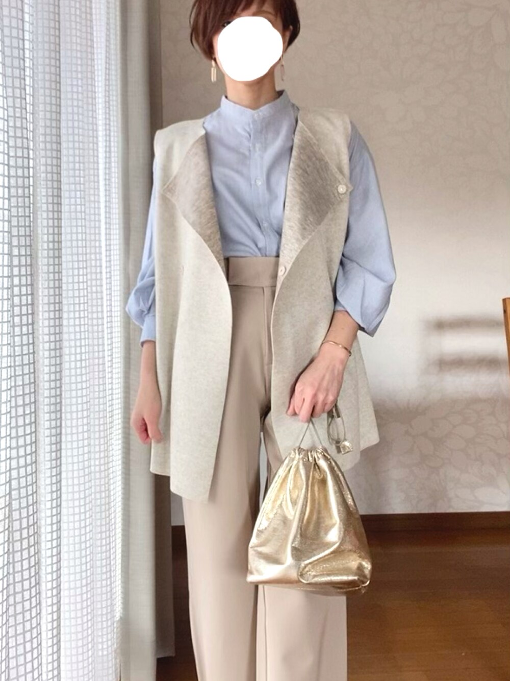 ベージュ系のベストを着用したレディースの冬コーディネートの1枚目の写真