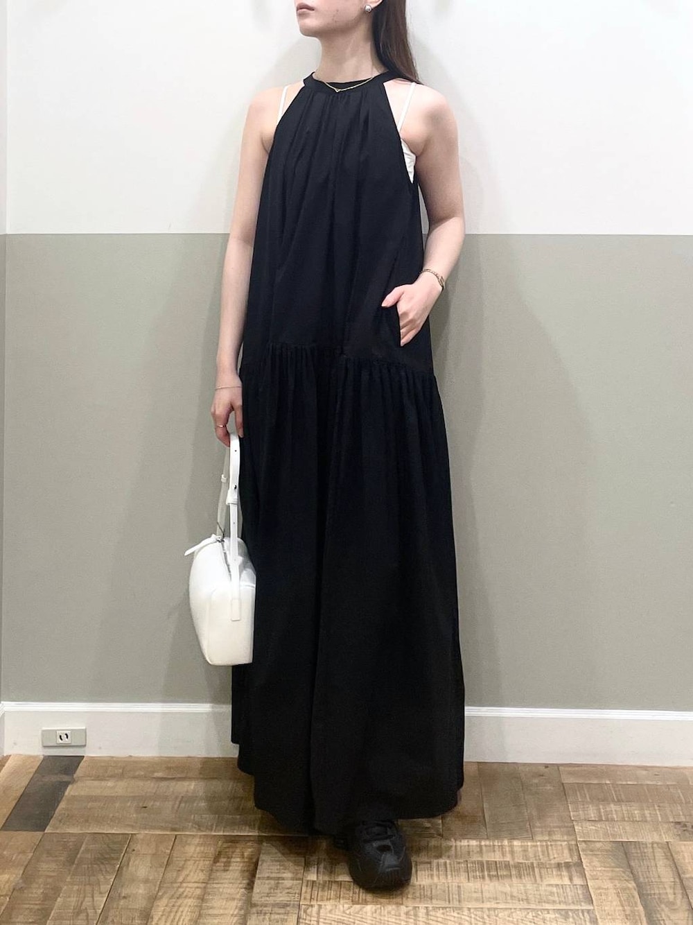 ホワイト系のハンドバッグ、ブラック系のワンピース、ホワイト系のキャミソールを着用したレディースの夏コーディネートの1枚目の写真