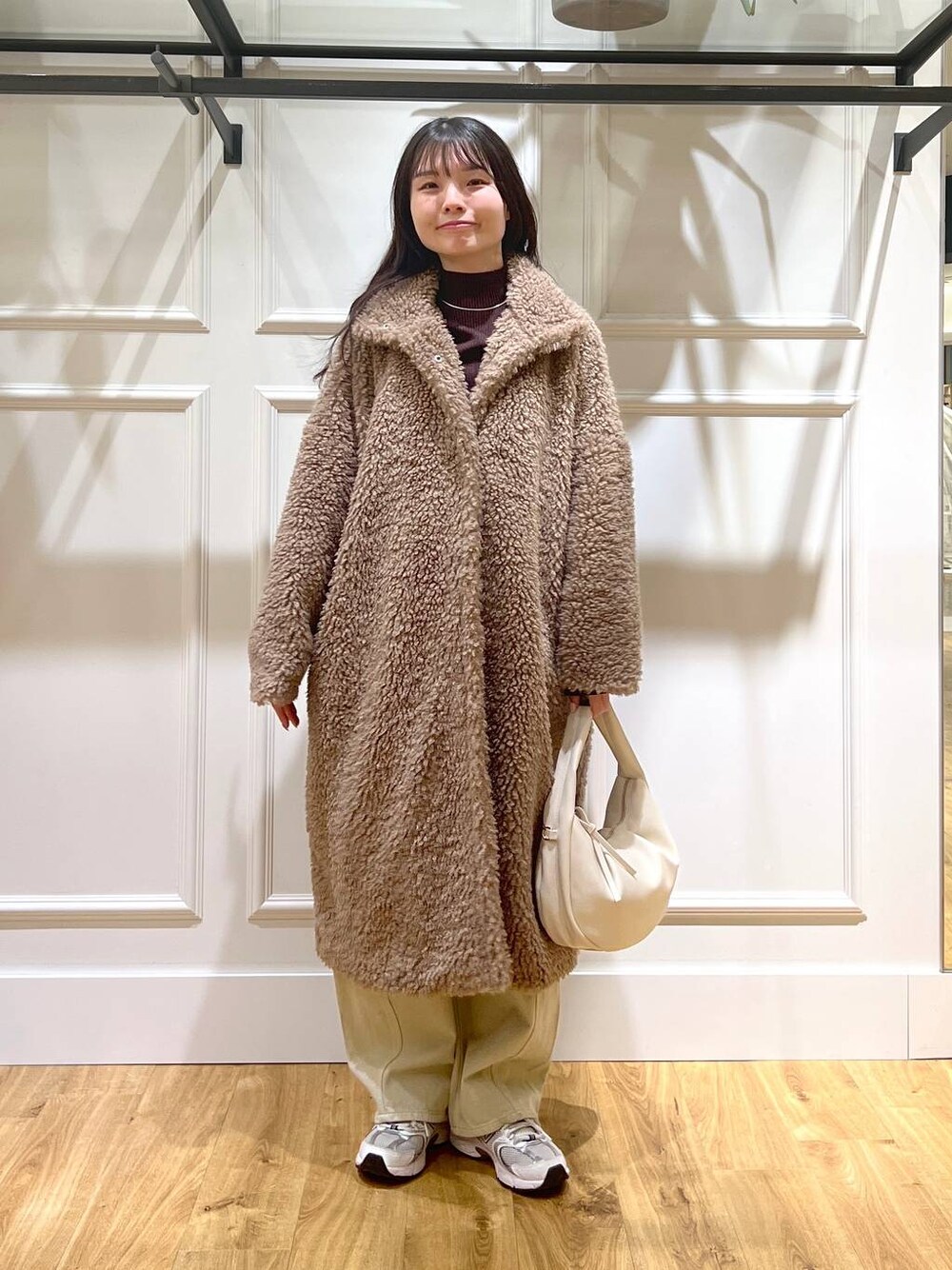 ベージュ系のデニムパンツ、ホワイト系のハンドバッグ、ベージュ系のその他アウターを着用したレディースの冬コーディネートの1枚目の写真