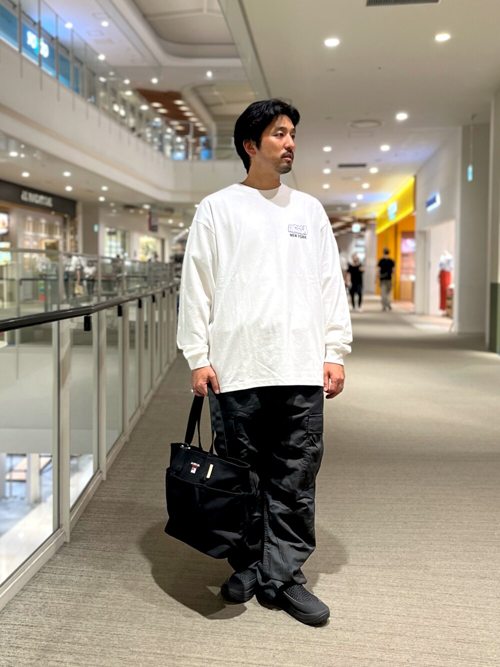 ブラック系のトートバッグ、その他のカーゴパンツ、ホワイト系のTシャツ/カットソーを着用したメンズの夏コーディネートの1枚目の写真