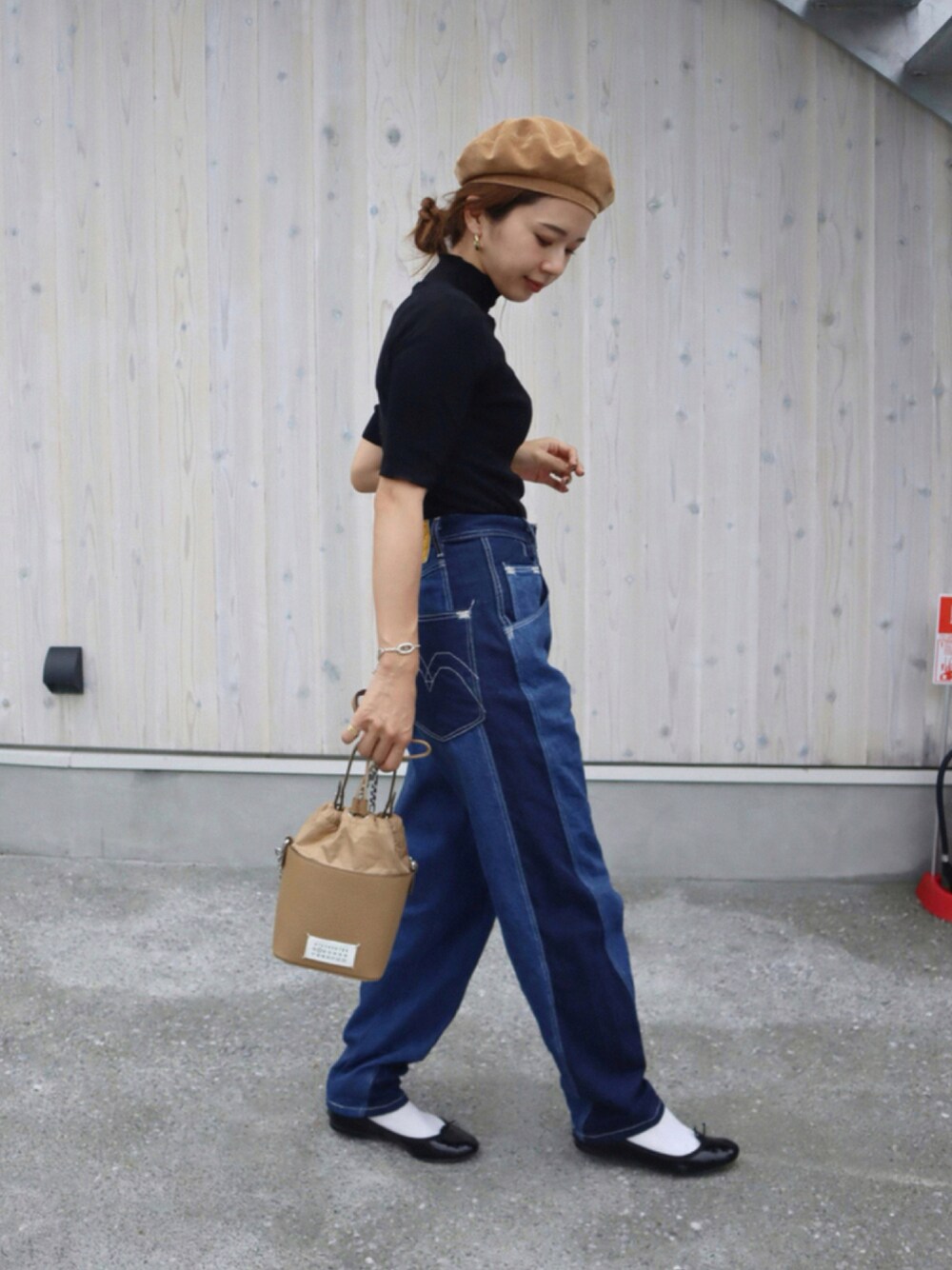 ベージュ系のショルダーバッグ、ブラック系のバレエシューズ、ブルー系のデニムパンツを着用したレディースの秋コーディネートの1枚目の写真