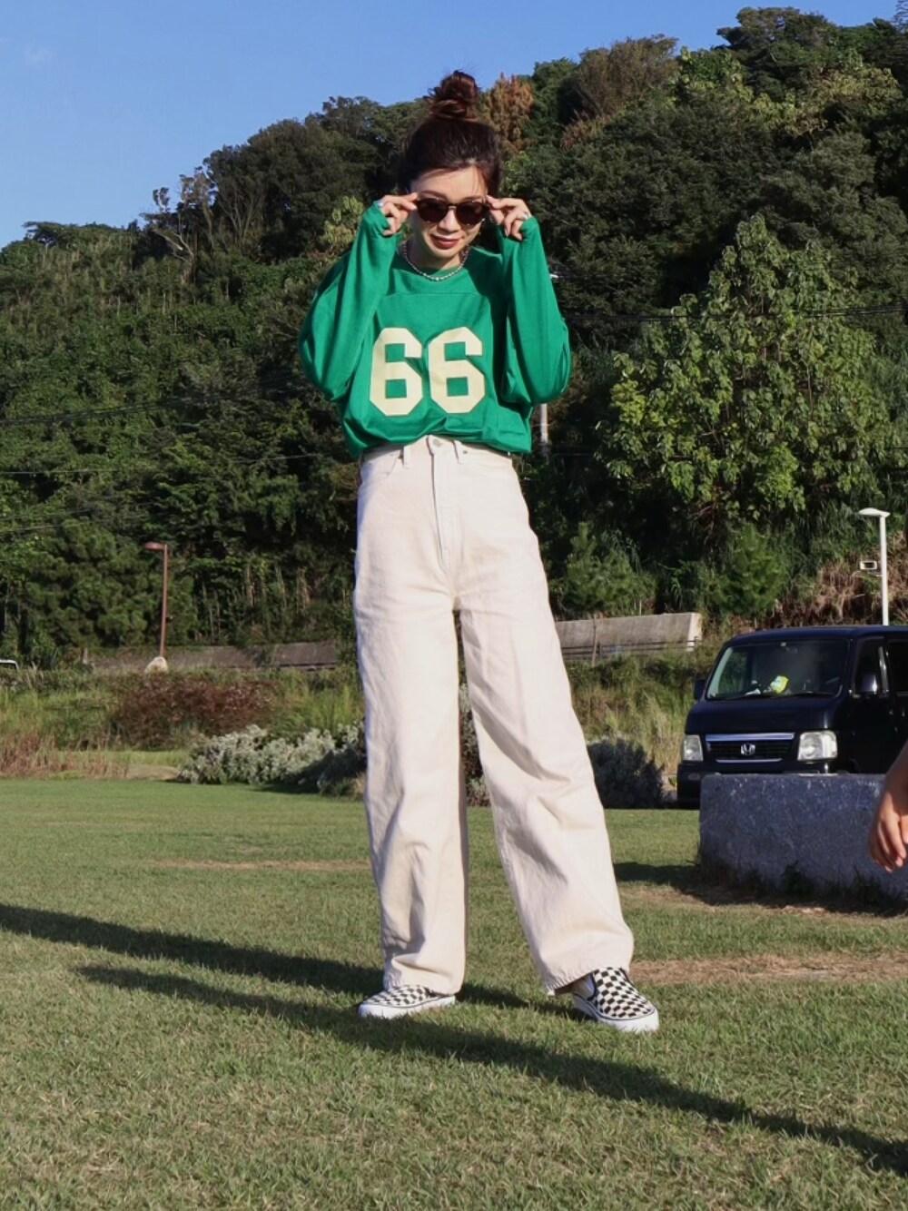 グリーン系のTシャツ/カットソー、ホワイト系のデニムパンツ、その他のスニーカーを着用したレディースの秋コーディネートの1枚目の写真