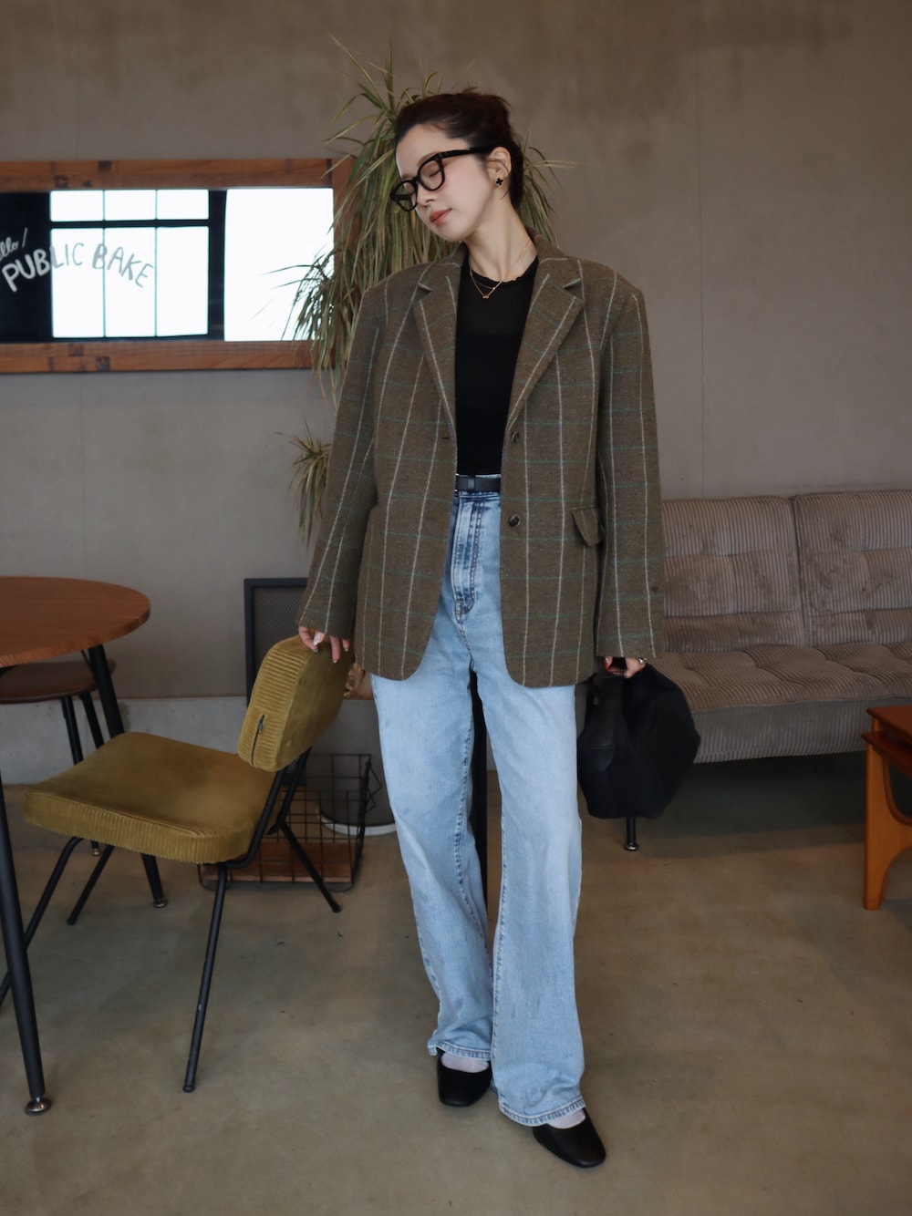 ブラック系のTシャツ/カットソー、ブルー系のデニムパンツを着用したレディースの秋コーディネートの1枚目の写真