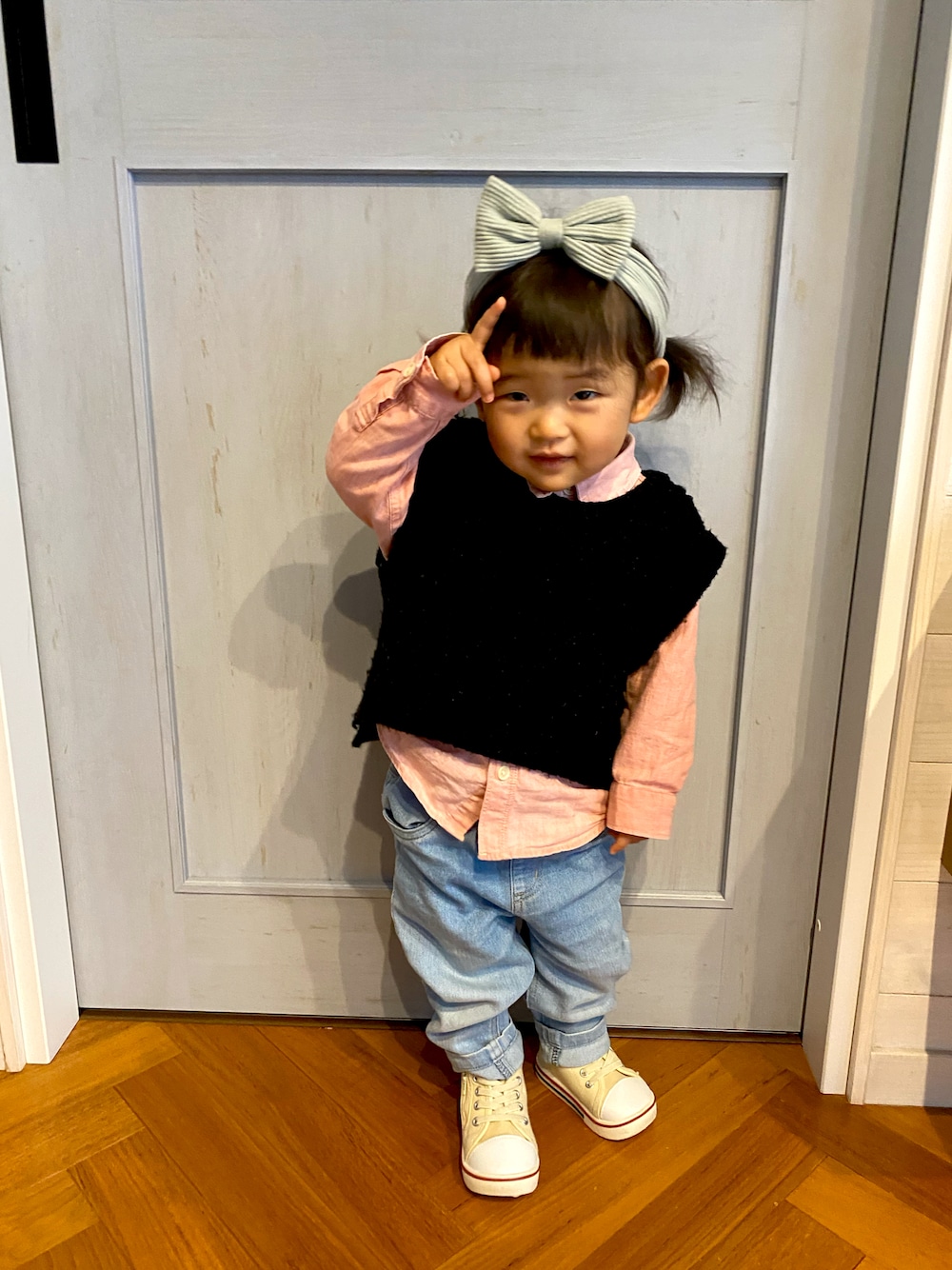 ブラック系のワンピース、ピンク系のシャツ/ブラウス、ホワイト系のスニーカーを着用したキッズの春コーディネートの1枚目の写真