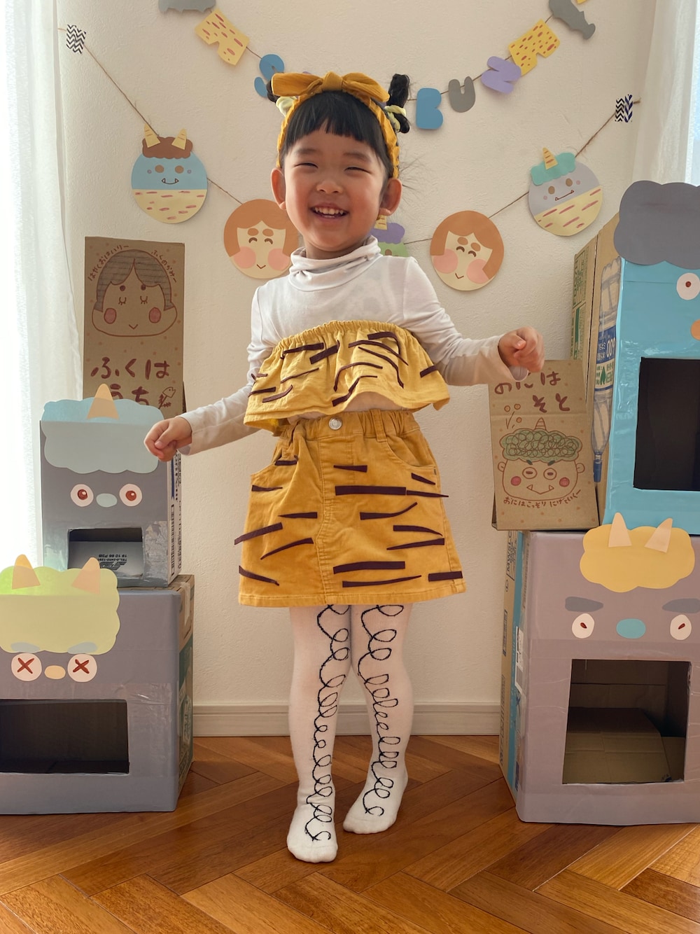 イエロー系のスカート、ホワイト系のタイツ/ストッキング、イエロー系のスタイ/よだれかけを着用したキッズの冬コーディネートの1枚目の写真