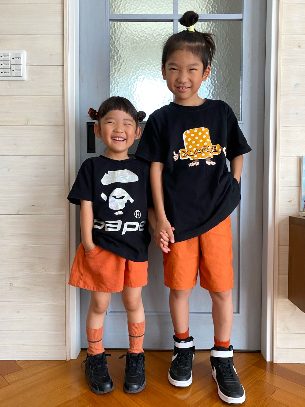 ブラック系のTシャツ/カットソー、オレンジ系のパンツ、ブラック系のTシャツ/カットソーを着用したキッズの夏コーディネートの1枚目の写真