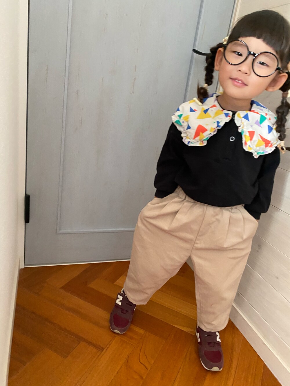 ブラック系のスウェット、ベージュ系のその他パンツ、レッド系のスニーカーを着用したキッズの秋コーディネートの1枚目の写真