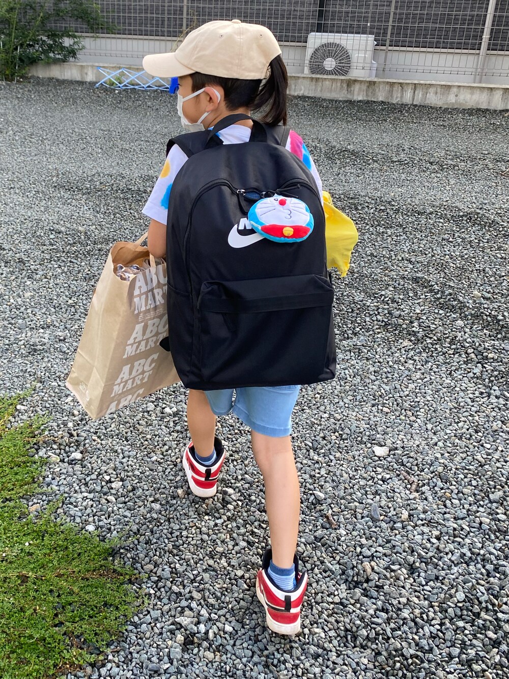 ブラック系のバックパック/リュック、ホワイト系のTシャツ/カットソー、レッド系のスニーカーを着用したキッズの夏コーディネートの1枚目の写真