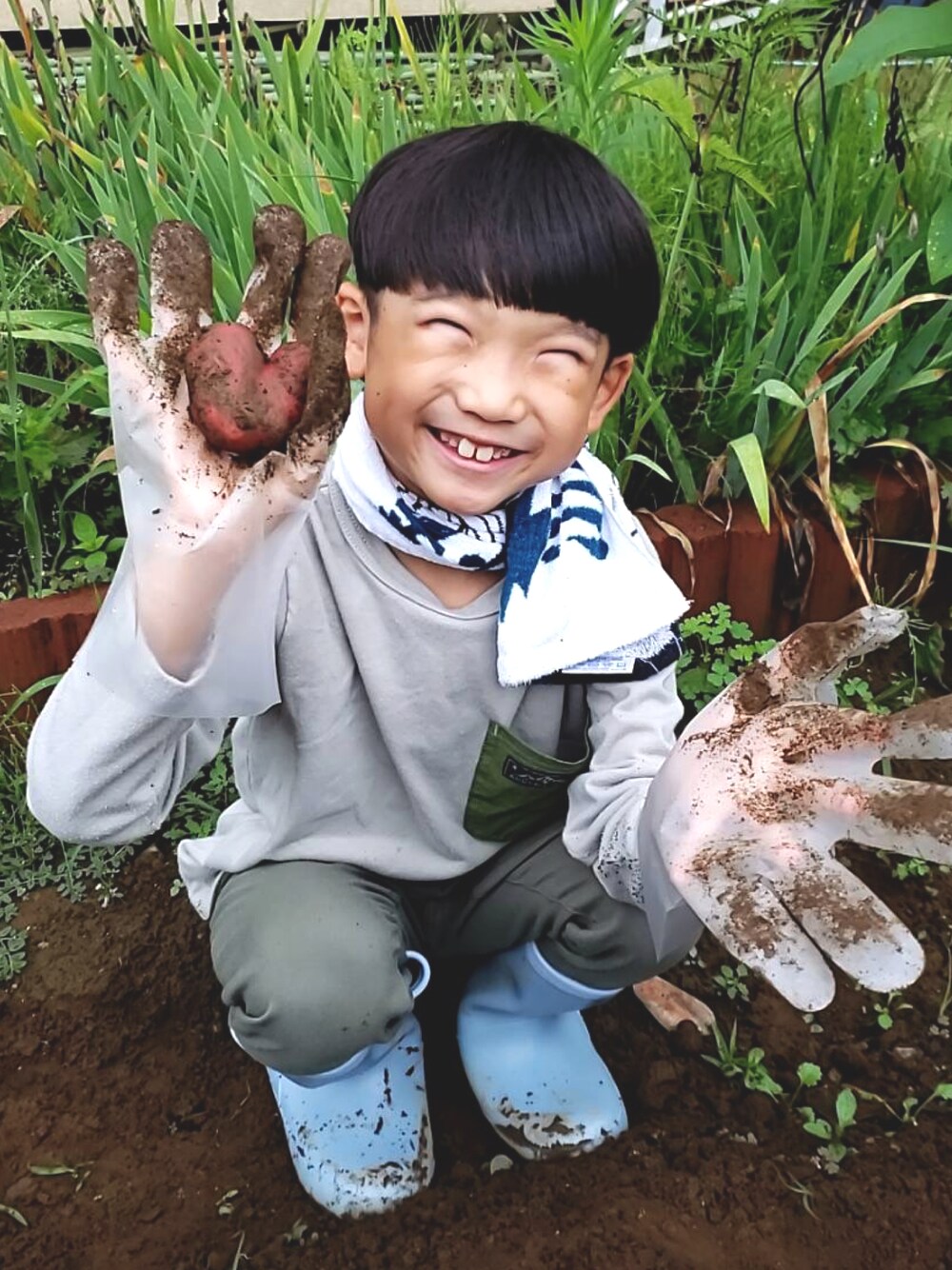 グリーン系のTシャツ/カットソー、グリーン系のパンツ、ブルー系のレインシューズを着用したキッズの夏コーディネートの1枚目の写真