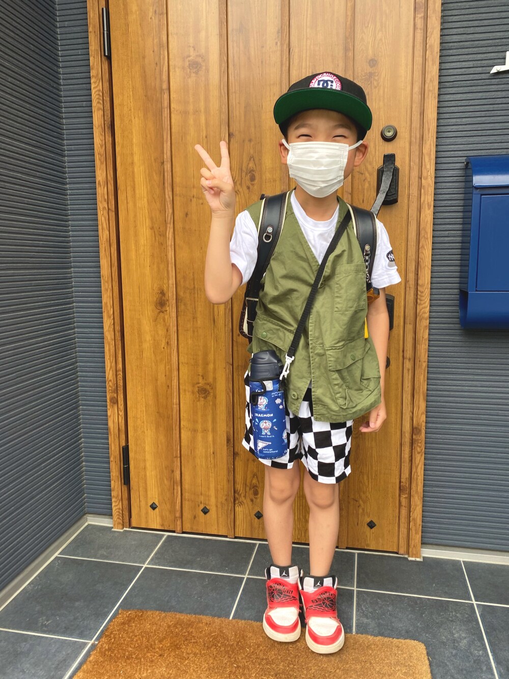 グリーン系のベスト、その他のその他パンツ、レッド系のスニーカーを着用したキッズの春コーディネートの1枚目の写真