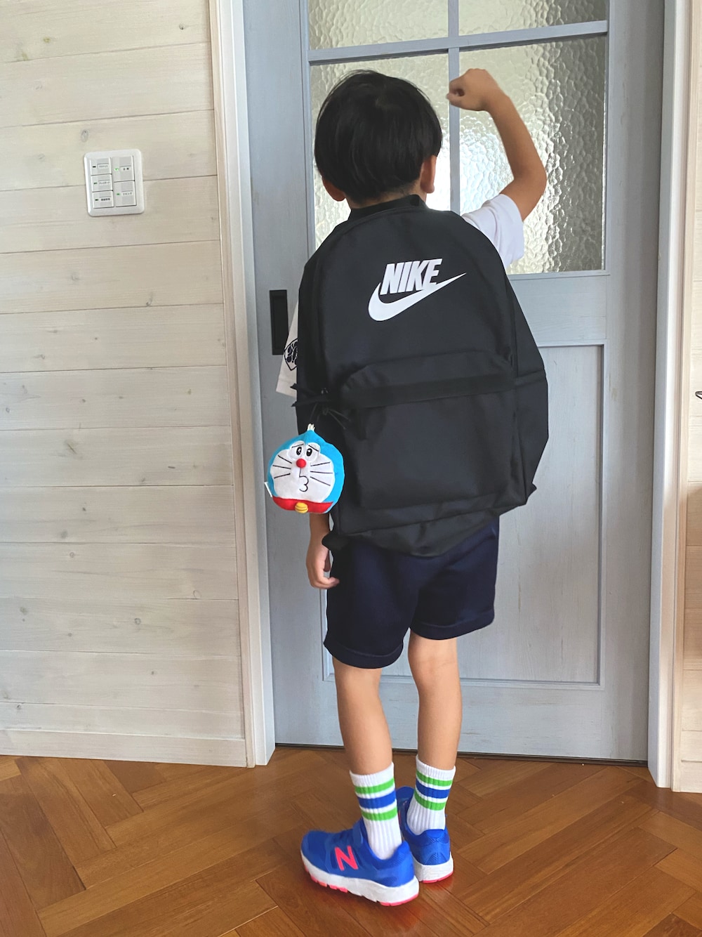 ブラック系のバックパック/リュック、ブルー系のスニーカー、ホワイト系のソックス/靴下を着用したキッズの秋コーディネートの1枚目の写真