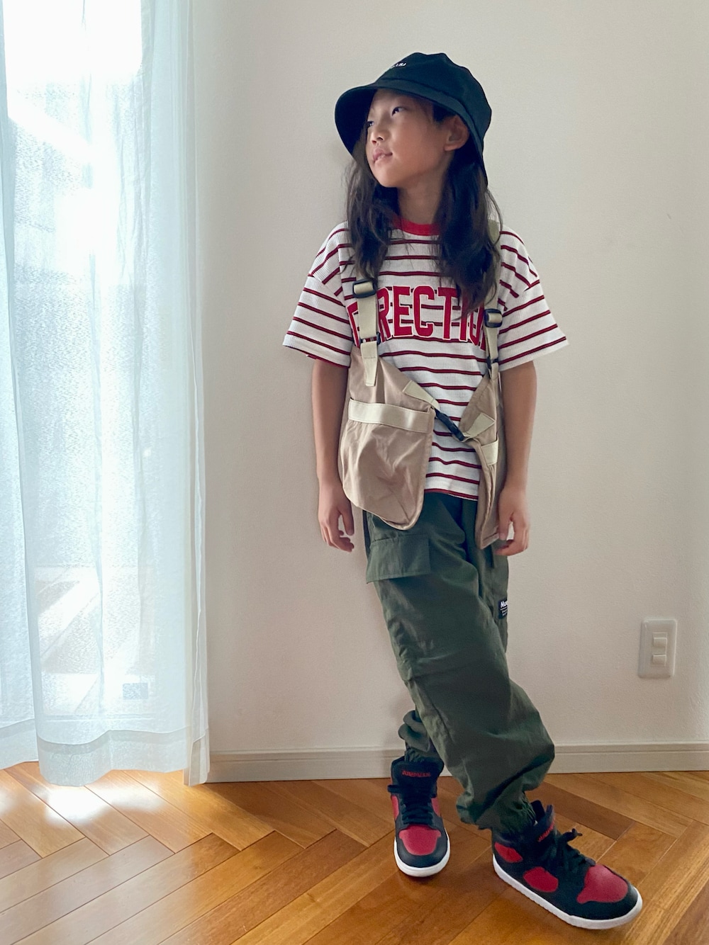 グリーン系のカーゴパンツ、ホワイト系のTシャツ/カットソー、ベージュ系のベストを着用したキッズの秋コーディネートの1枚目の写真