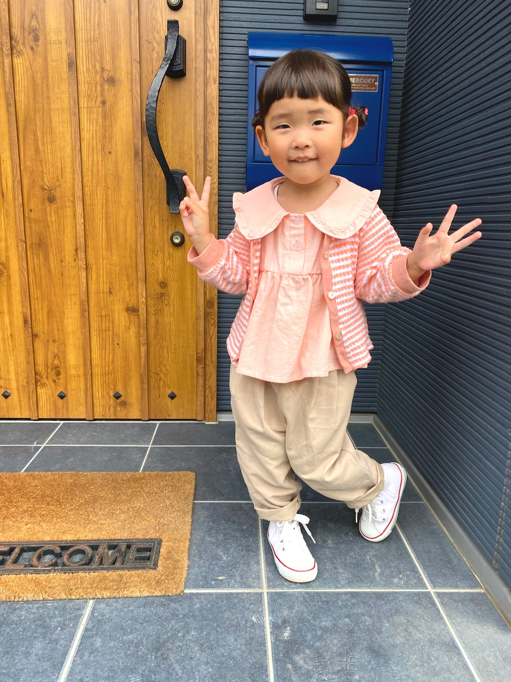 ピンク系のトップス、ベージュ系のその他パンツ、ピンク系のカーディガン/ボレロを着用したキッズの春コーディネートの1枚目の写真