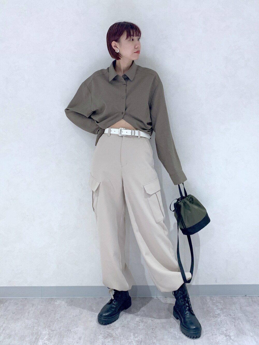 ブラウン系のシャツ/ブラウス、ベージュ系のパンツ、ブラック系のブーツを着用したレディースの秋コーディネートの1枚目の写真