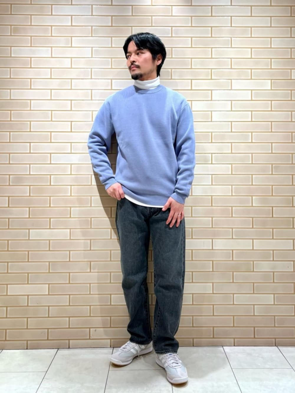 ブルー系のニット/セーター、ホワイト系のTシャツ/カットソー、ブラック系のデニムパンツを着用したメンズの冬コーディネートの1枚目の写真