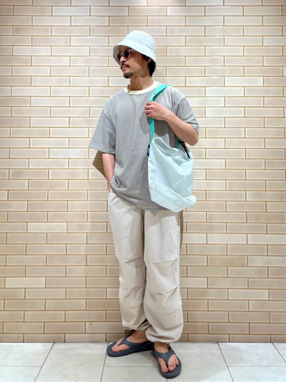 ホワイト系のその他パンツ、ベージュ系のTシャツ/カットソー、ホワイト系のショルダーバッグを着用したメンズの春コーディネートの1枚目の写真