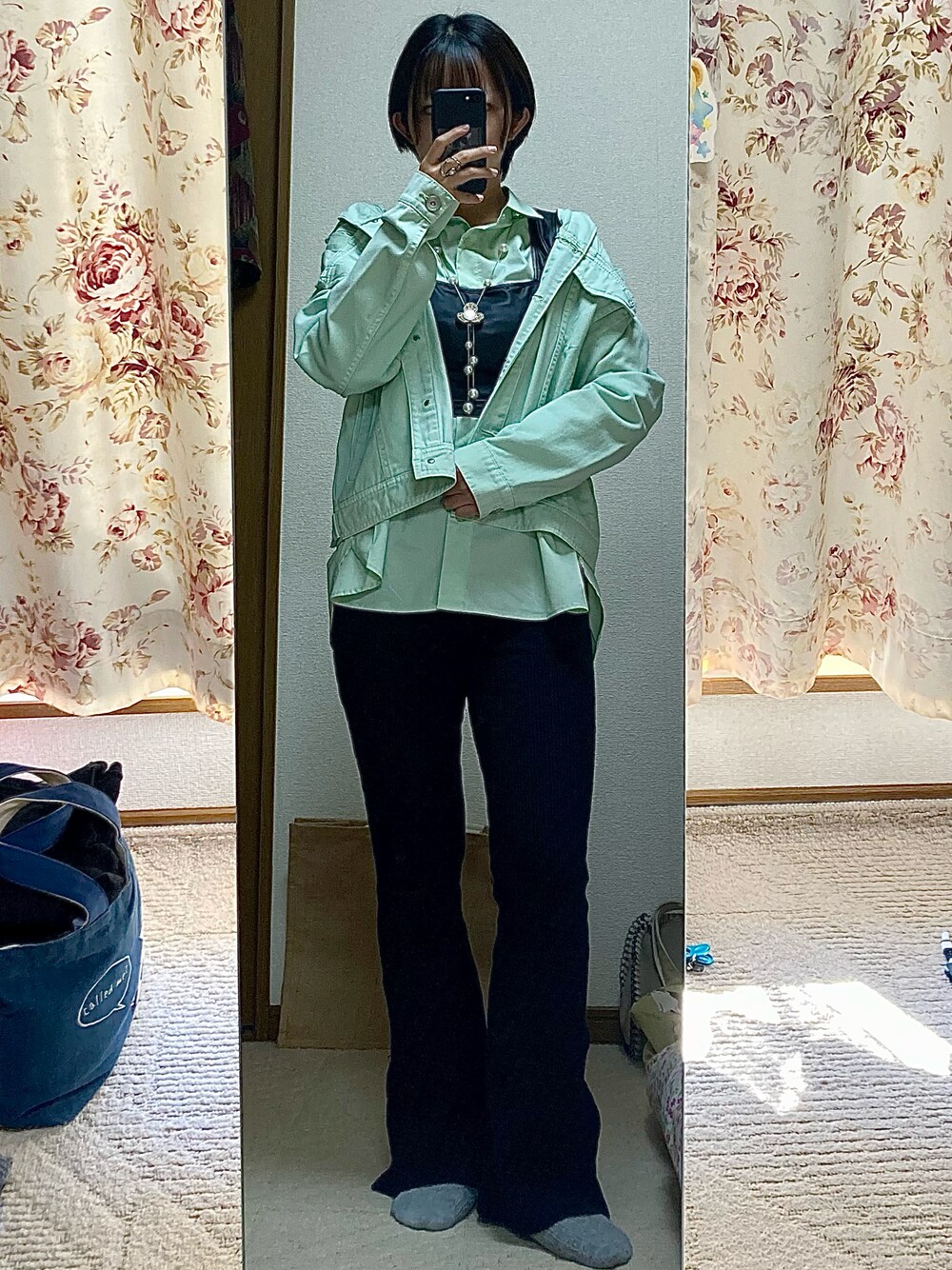 グリーン系のデニムジャケット、グリーン系のシャツ/ブラウス、ブラック系のパンツを着用したレディースの秋コーディネートの1枚目の写真