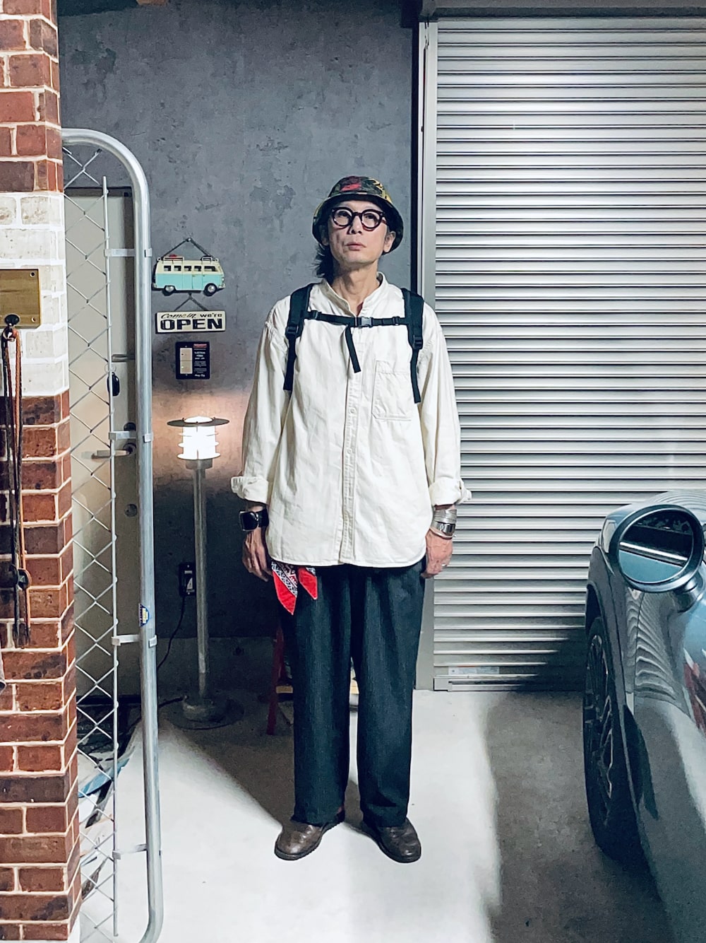 「スタンドカラー、バンドカラーシャツ、シャツスタイル、シャツ、スラックス、バケットハット、迷彩、白シャツ、春コーデ、春、カジュアル、カジュアルコーデ、シンプルコーデ、ストライプパンツ、バックパック」｜「古着のアイテム（スラックス、ブラック系）」を使った、h.s.k.さん（メンズ・176cm）の夏コーディネートの1枚目の写真