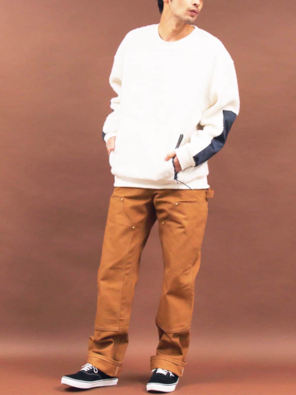 ブラウン系のチノパンツ、ブラック系のスニーカーを着用したメンズの冬コーディネートの1枚目の写真