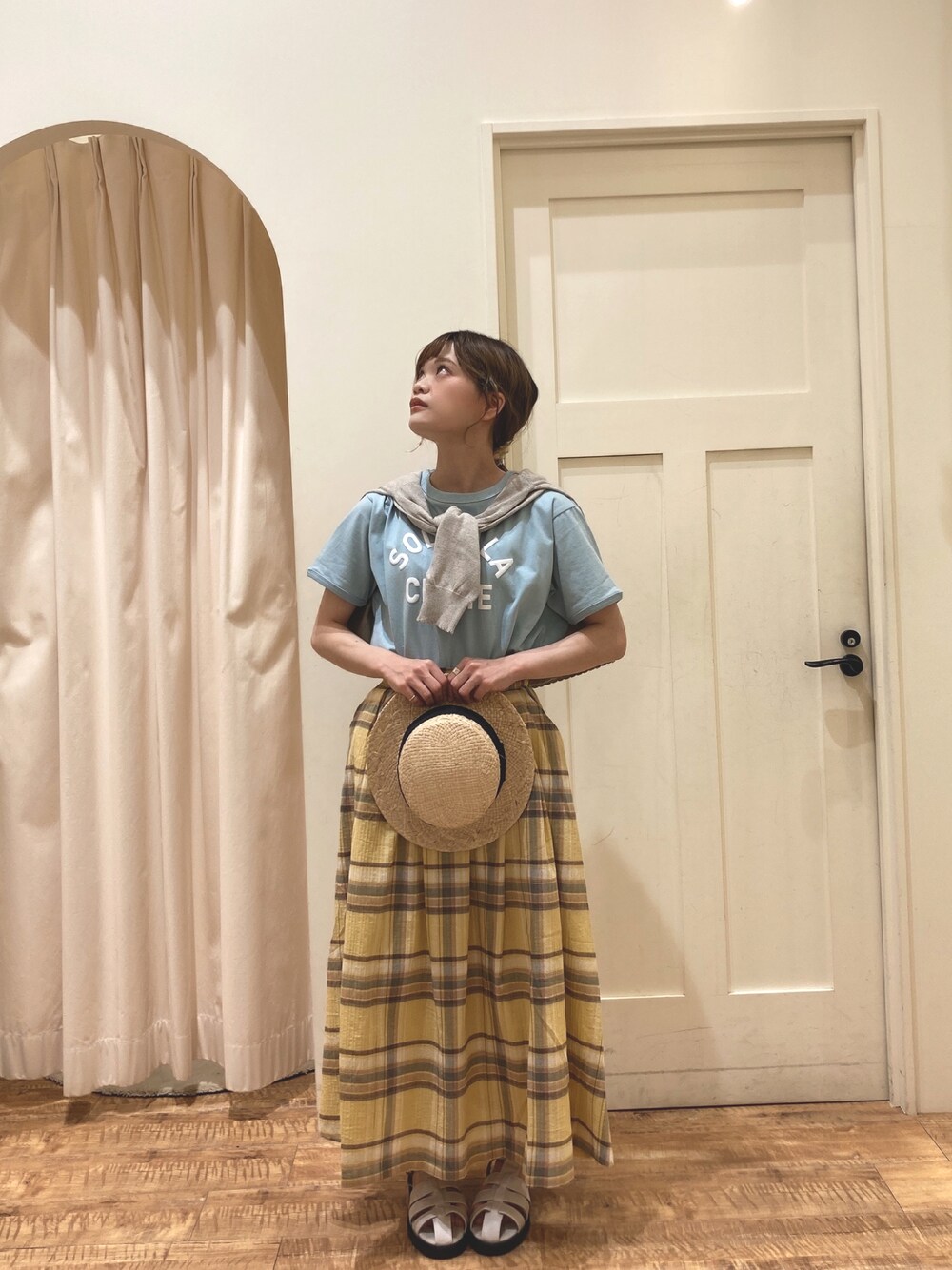 ブルー系のTシャツ/カットソー、イエロー系のスカート、ベージュ系のカーディガン/ボレロを着用したレディースの春コーディネートの1枚目の写真