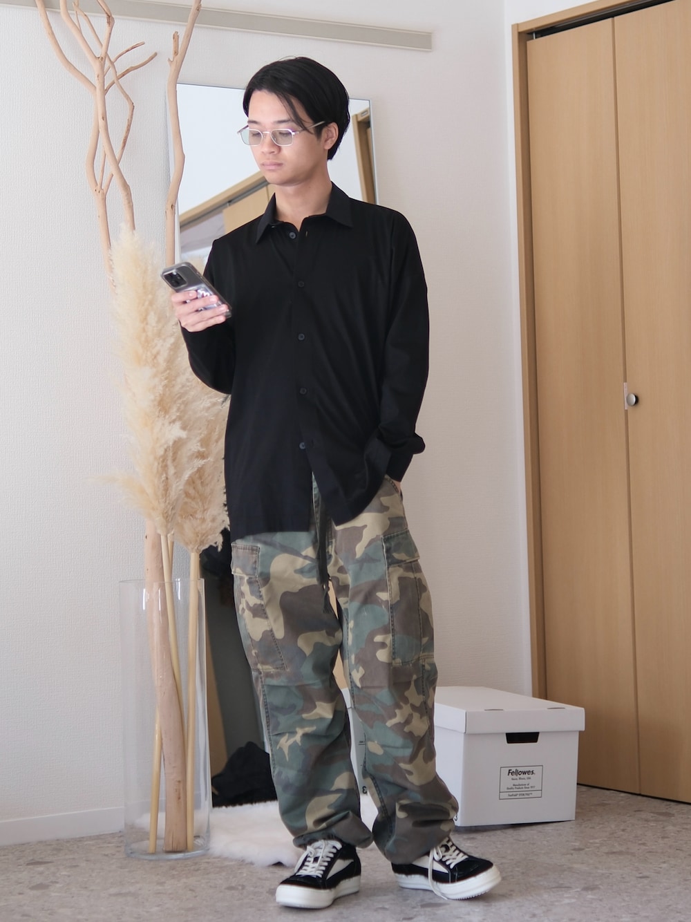 ブラック系のシャツ/ブラウス、グリーン系のカーゴパンツ、ブラック系のスニーカーを着用したメンズの春コーディネートの1枚目の写真