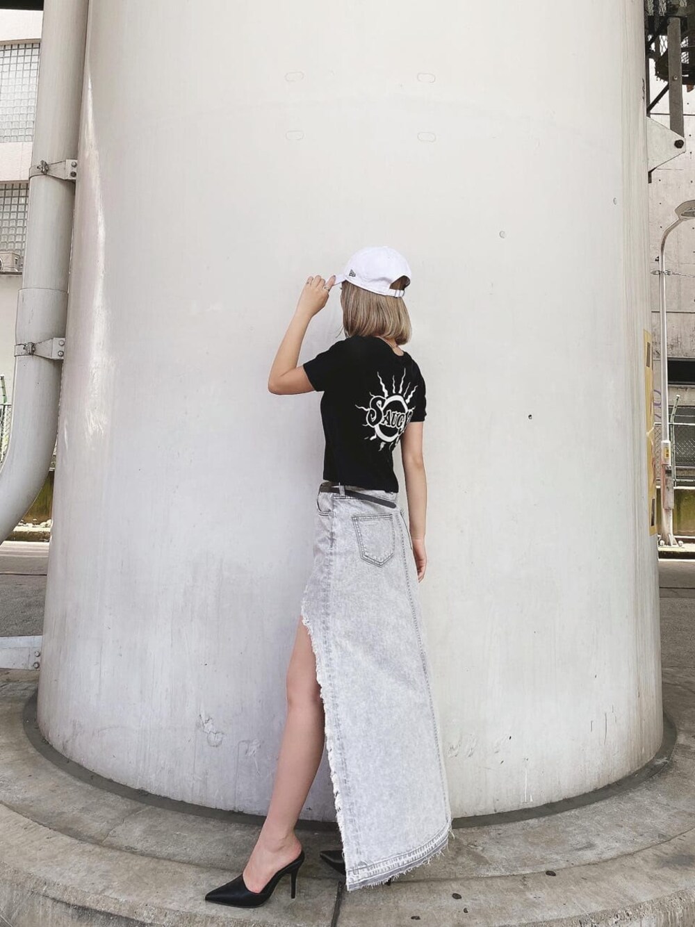 グレー系のデニムスカート、ブラック系のTシャツ/カットソー、ブラック系のパンプスを着用したレディースの夏コーディネートの1枚目の写真