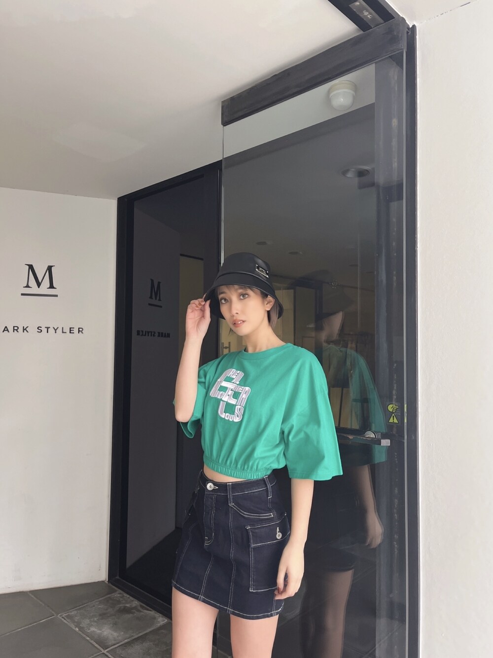 グリーン系のTシャツ/カットソー、ブルー系のデニムスカートを着用したレディースの夏コーディネートの1枚目の写真