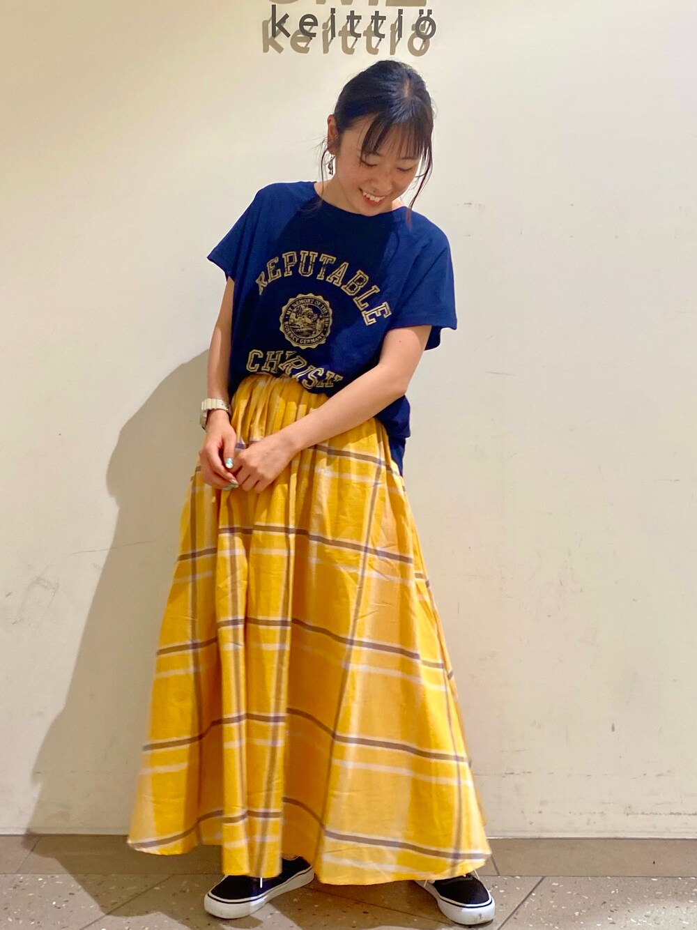 イエロー系のスカート、ブルー系のTシャツ/カットソーを着用したレディースの夏コーディネートの1枚目の写真