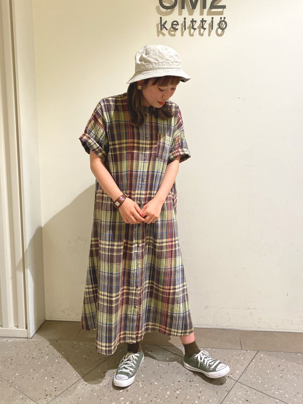 グリーン系のワンピース、グレー系の帽子を着用したレディースの夏コーディネートの1枚目の写真