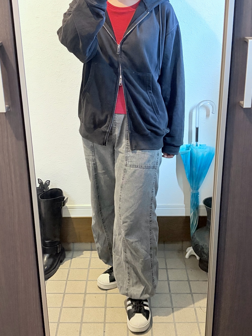 レッド系のタンクトップ、ブラック系のパーカー、グレー系のその他パンツを着用したレディースの秋コーディネートの1枚目の写真