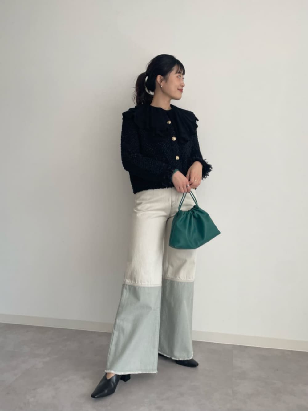 ブラック系のカーディガン/ボレロ、ブラック系のニット/セーター、ホワイト系のデニムパンツを着用したレディースの冬コーディネートの1枚目の写真