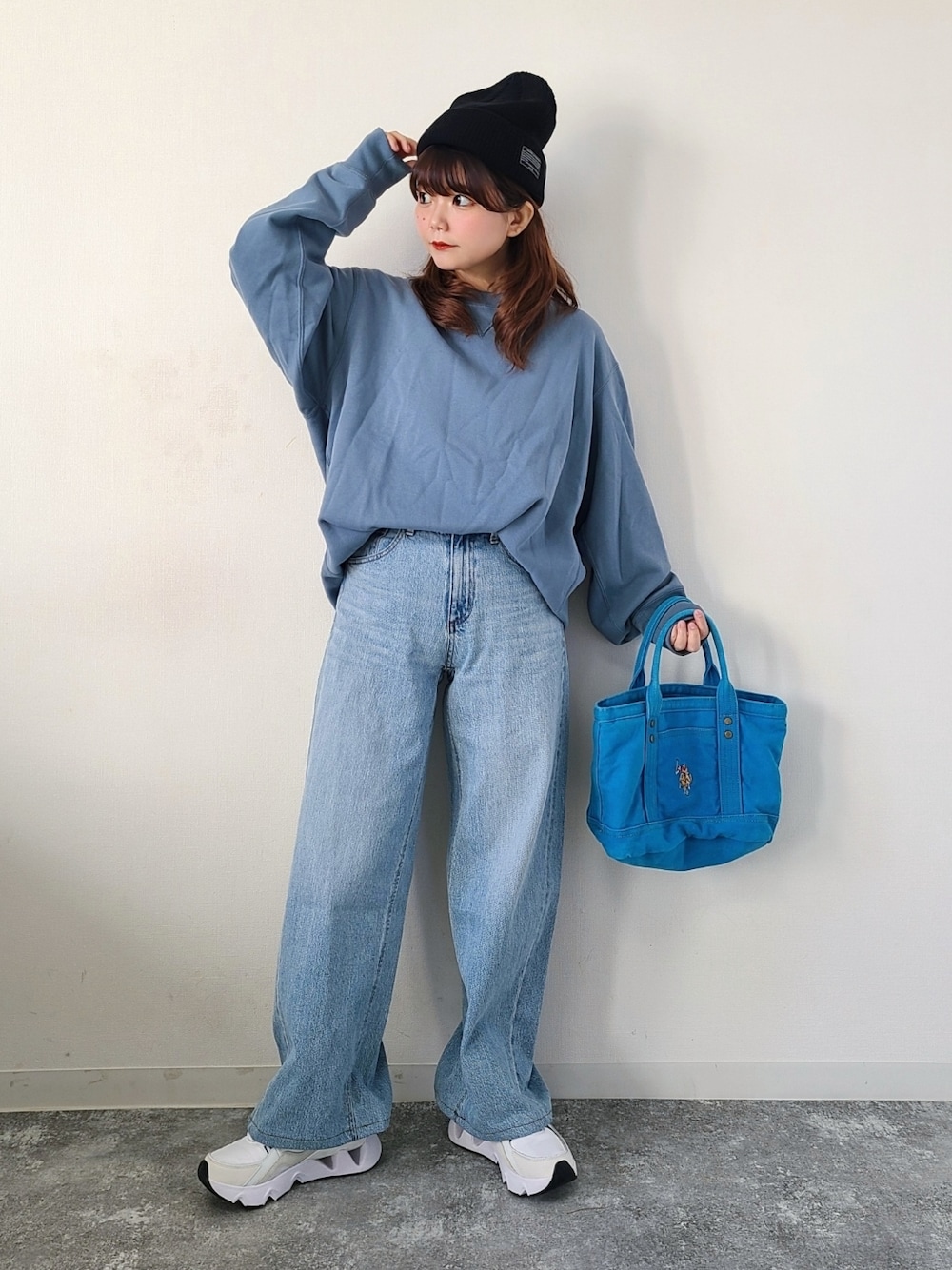 ブルー系のスウェット、ブルー系のデニムパンツ、ブルー系のトートバッグを着用したレディースの春コーディネートの1枚目の写真