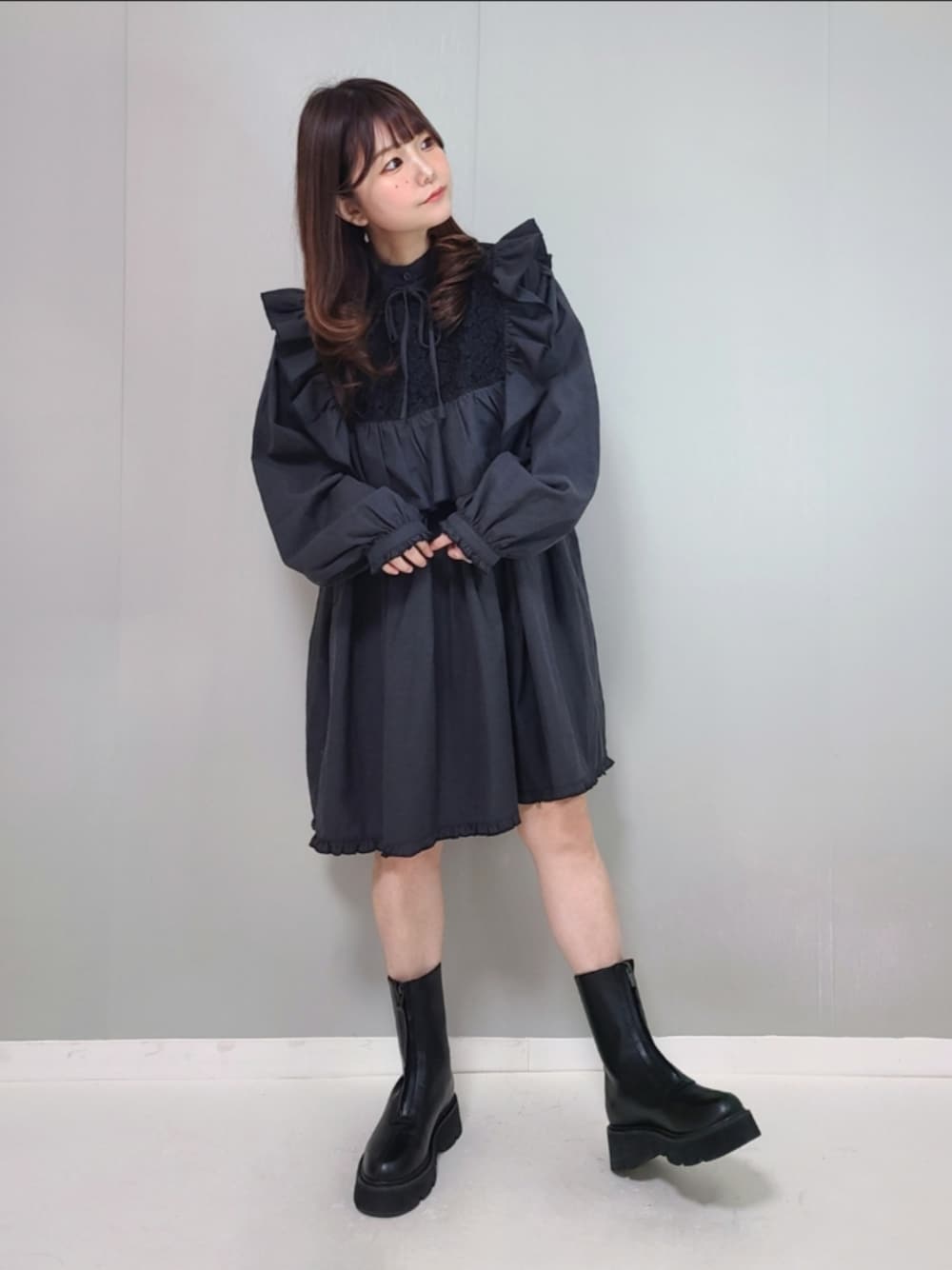 ブラック系のワンピース、ブラック系のブーツを着用したレディースの冬コーディネートの1枚目の写真