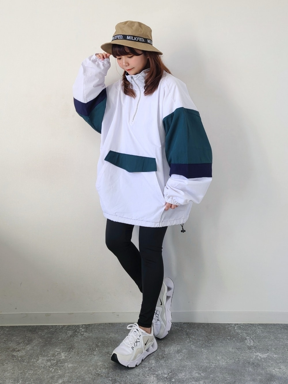 ホワイト系のナイロンジャケット、ホワイト系のスニーカー、ブラック系のレギンス/スパッツを着用したレディースの春コーディネートの1枚目の写真