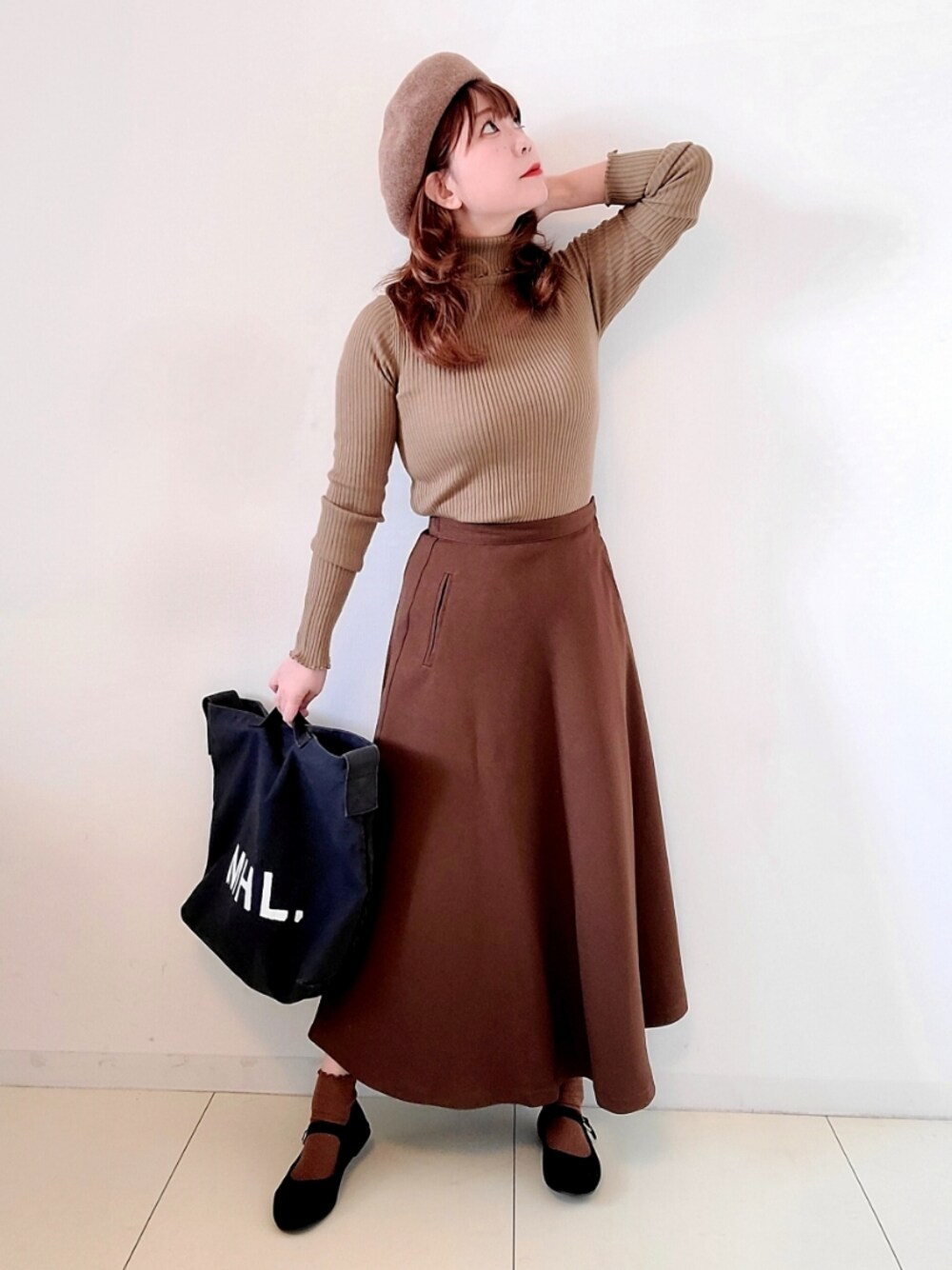 ブラック系のショルダーバッグ、ブラウン系のスカート、ブラック系のバレエシューズを着用したレディースの秋コーディネートの1枚目の写真