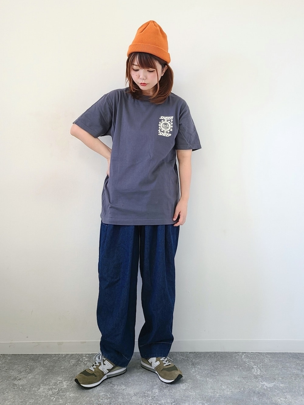 グレー系のTシャツ/カットソー、ブルー系のデニムパンツ、グリーン系のスニーカーを着用したレディースの秋コーディネートの1枚目の写真