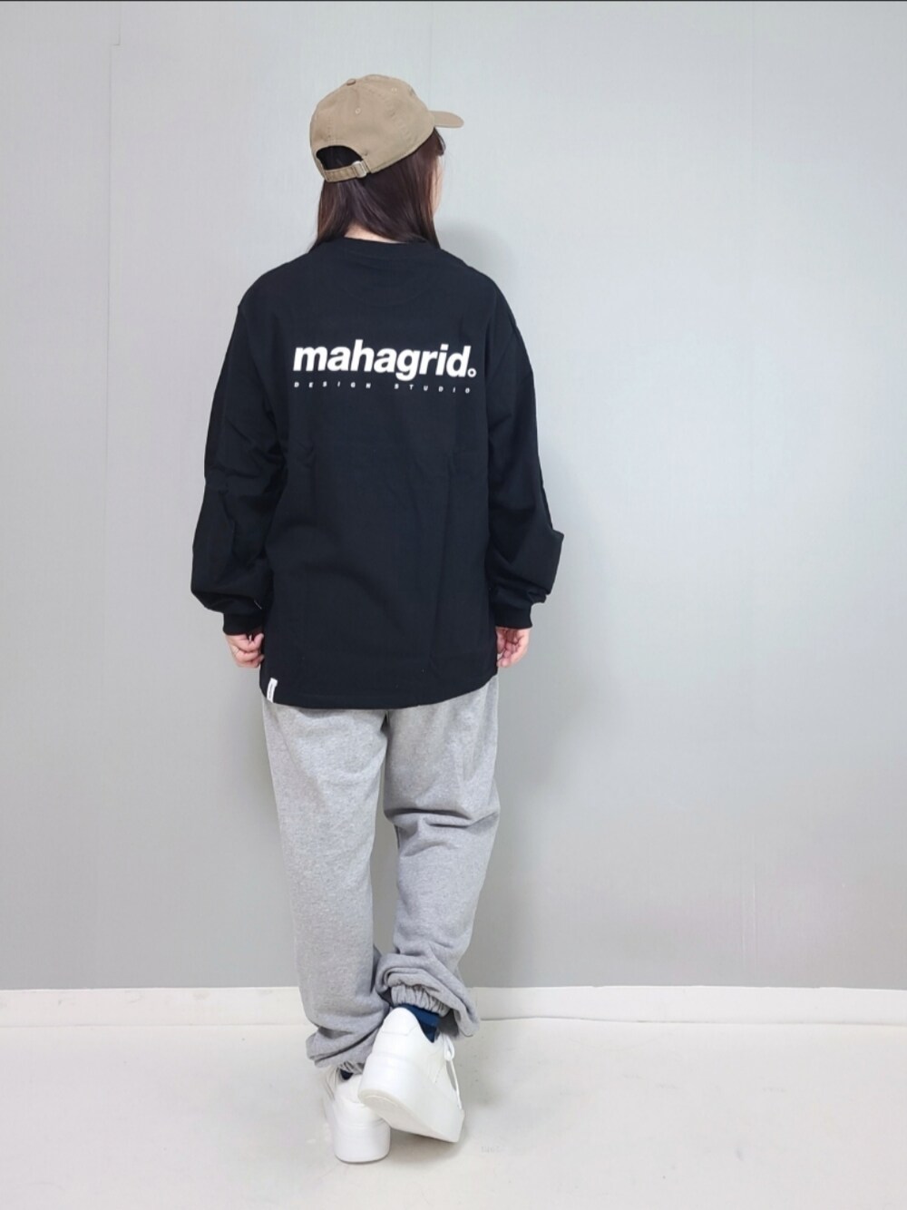 ブラック系のTシャツ/カットソー、グレー系のスウェットパンツ、ホワイト系のスニーカーを着用したレディースの冬コーディネートの1枚目の写真