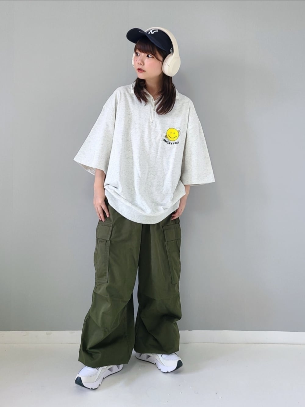 ベージュ系のTシャツ/カットソー、グリーン系のカーゴパンツ、ホワイト系のスニーカーを着用したレディースの夏コーディネートの1枚目の写真