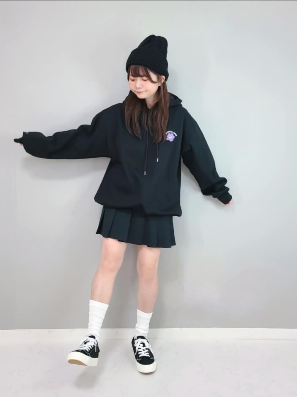 ブラック系のパーカー、ブラック系のスカートを着用したレディースの冬コーディネートの1枚目の写真