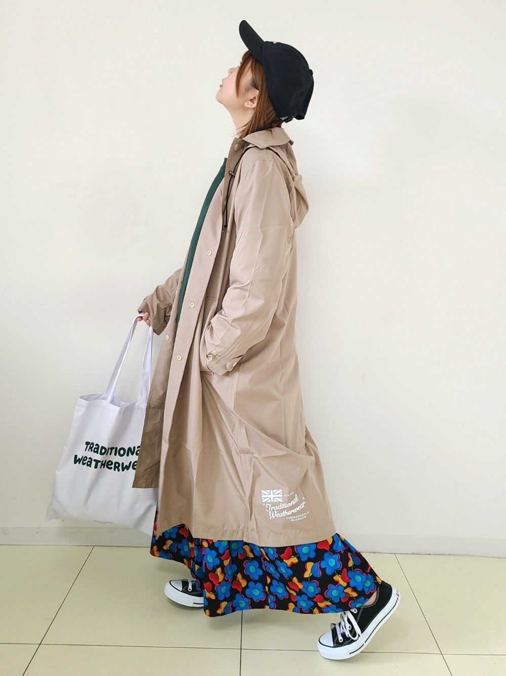 「Traditional Weatherwear、トラディショナルウェザーウエア、TWW、花柄、レインコート、春コーデ、キャップ、コンバース、スニーカーコーデ、休日スタイル、トートバッグ、雨の日コーデ」｜「Traditional WeatherwearのPENRITH RAIN PACKABLE / パッカブルレインコート（レインコート/ポンチョ、ベージュ系）」を使った、パン粉さん（レディース・151cm）の春コーディネートの1枚目の写真