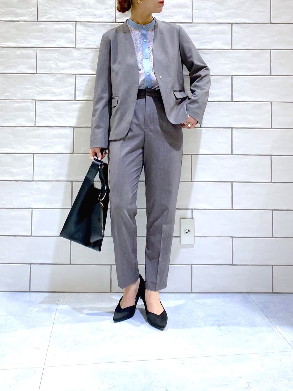 グレー系のノーカラージャケット、ブルー系のシャツ/ブラウス、グレー系のその他パンツを着用したレディースの冬コーディネートの2枚目の写真