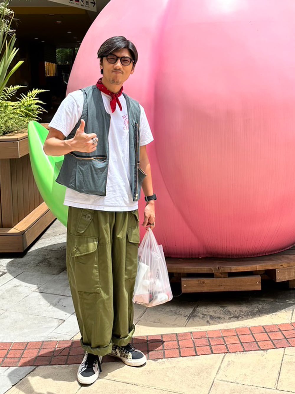 ブラック系のスニーカー、グリーン系のカーゴパンツを着用したメンズの夏コーディネートの1枚目の写真