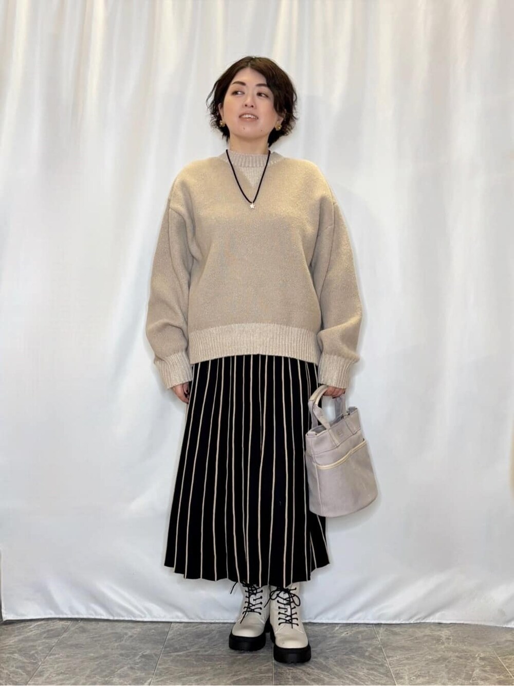 ベージュ系のニット/セーターを着用したレディースの冬コーディネートの1枚目の写真