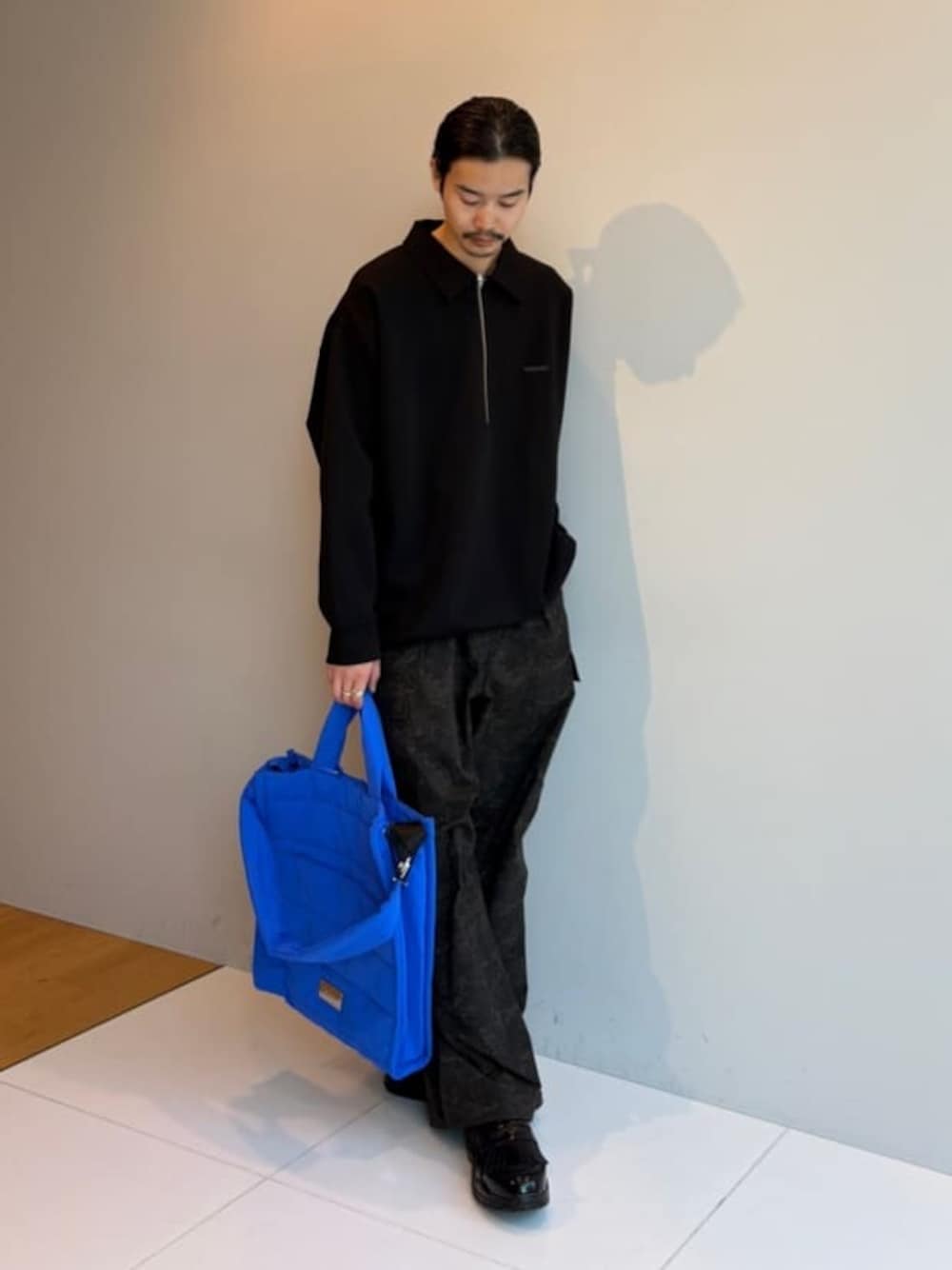 ブラック系のTシャツ/カットソー、グリーン系のカーゴパンツを着用したメンズの冬コーディネートの1枚目の写真