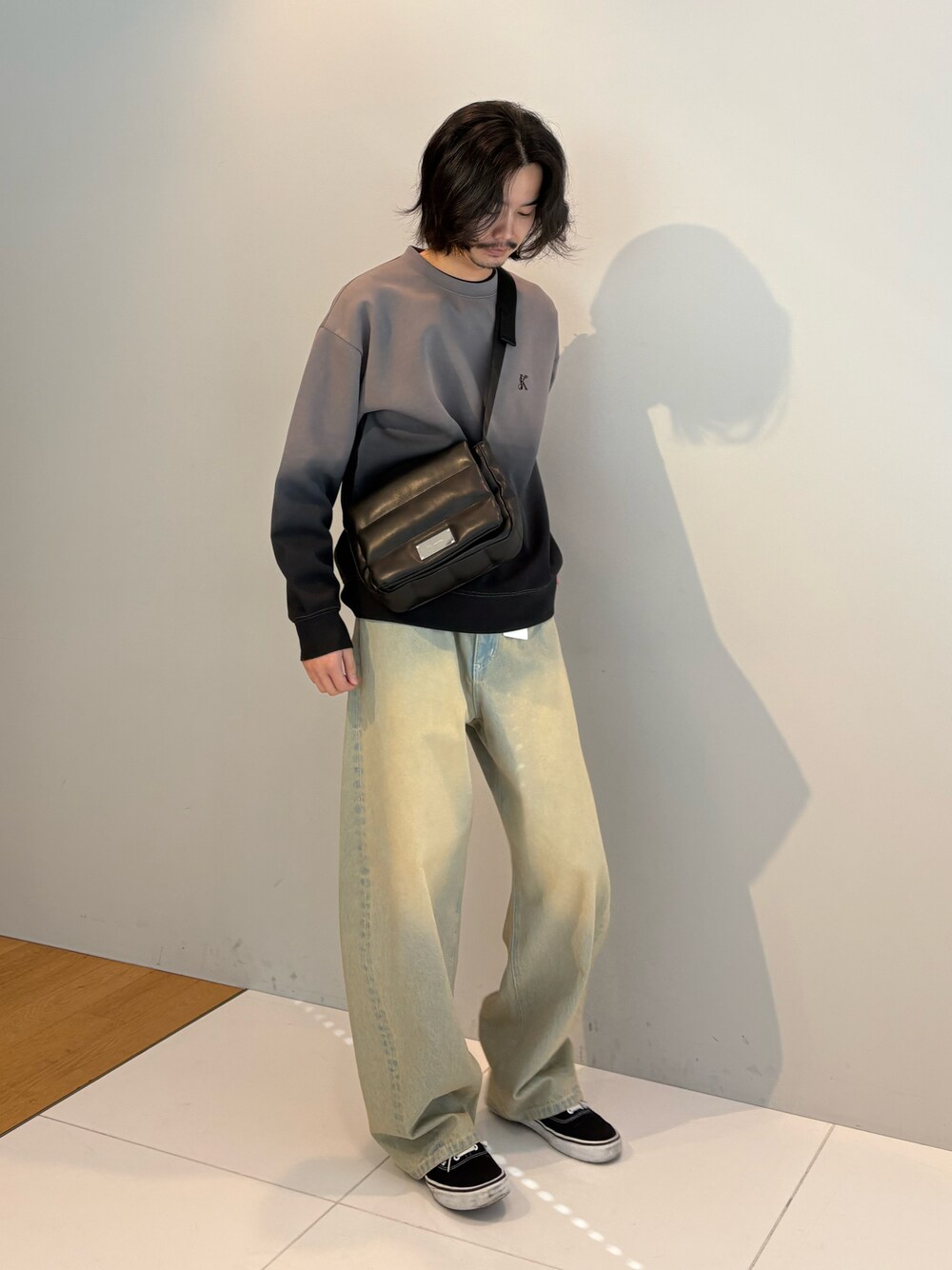 グレー系のTシャツ/カットソー、ブルー系のデニムパンツ、ブラック系のショルダーバッグを着用したメンズの冬コーディネートの1枚目の写真