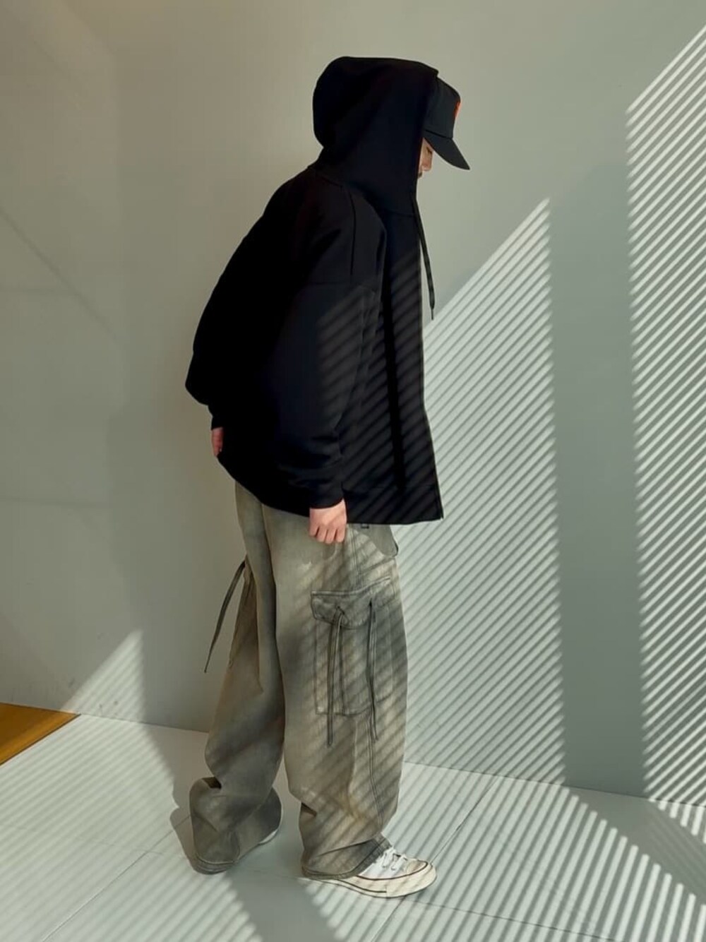 ブラック系のカーゴパンツ、ブラック系のパーカーを着用したメンズの冬コーディネートの1枚目の写真